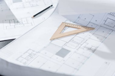close-up shot of architecture plans and drawing supplies on table