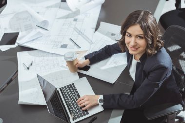 güzel genç mimar kahve ile laptop ile çalışma gitmek yüksek açılı görünüş