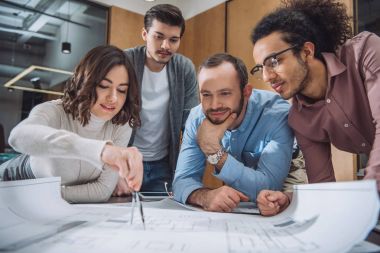 group of architects drawing building plan together at office