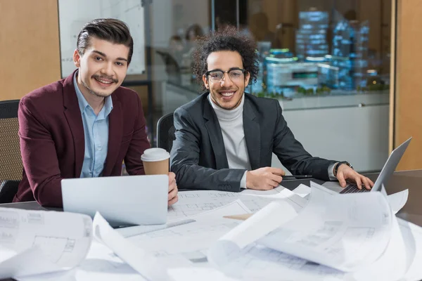 Jóvenes Arquitectos Felices Con Planos Edificios Sentados Juntos Oficina — Foto de stock gratis