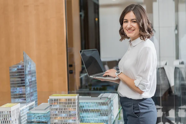 Feliz Jovem Arquiteto Usando Laptop Perto Modelos Construção — Fotografia de Stock