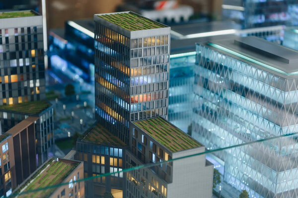 Close-up shot of plastic miniature model of modern city under glass
