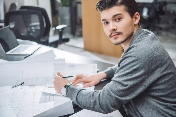 Schöner Junger Architekt Zeichnet Baupläne Büro Und Blickt Die Kamera — Stockfoto