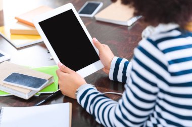 kulaklıklar ve tablet masada oturan öğrencinin kısmi görünümü