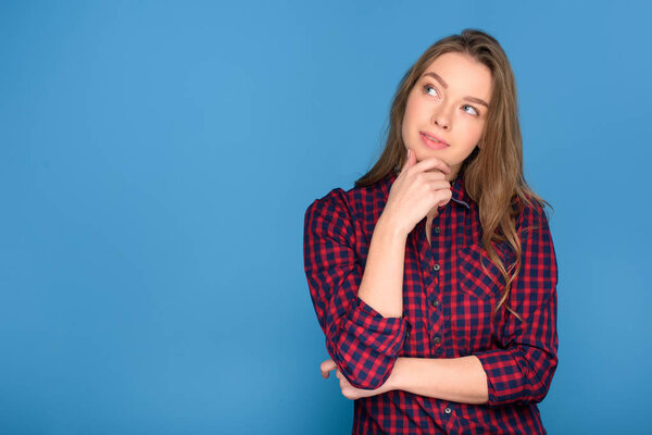 beautiful young thoughtful girl, isolated on blue