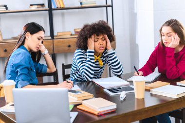 yorgun çok ırklı öğrenciler birlikte ödev