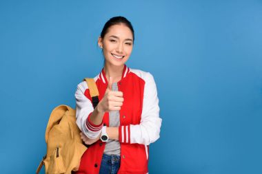 üzerinde izole mavi yukarı gösteren gülümseyen Asya öğrenci portresi