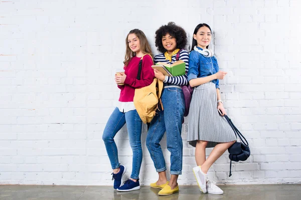 Jonge Multiraciale Studenten Permanent Tegen Witte Bakstenen Muur — Stockfoto