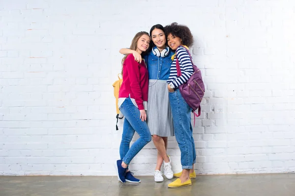 Asiático Estudiante Abrazando Sonriente Multiétnico Amigos Contra Blanco Ladrillo Pared — Foto de Stock