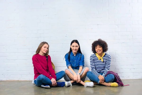 Grupo Estudantes Multirraciais Sentados Chão Contra Parede Tijolo Branco — Fotografia de Stock