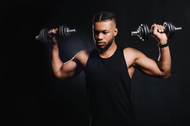 yakışıklı kaslı Afrikalı-Amerikalı adam siyah dumbbells ile egzersiz