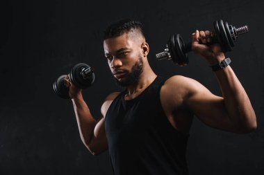 Afrika kökenli Amerikalı sporcu siyah izole dumbbells ile egzersiz konsantre 