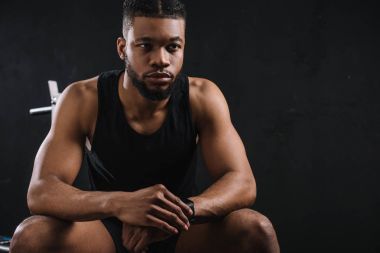 oturma ve uzak siyah üzerinde seyir yakışıklı genç Afro-Amerikan sporcu