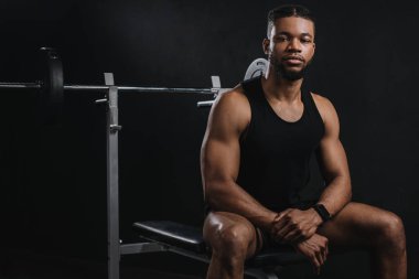 atletik Afro-Amerikan delikanlı oturan ve spor salonunda kamera seyir spor giyim
