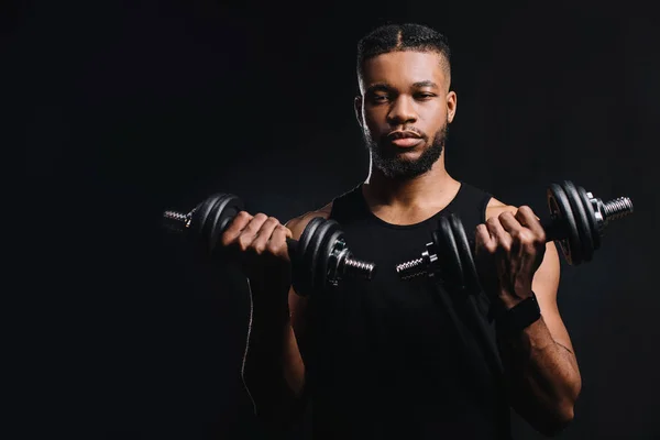 Bonito Jovem Desportista Segurando Halteres Olhando Para Câmera Isolada Preto — Fotografia de Stock