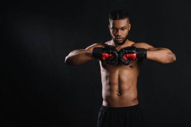 kas gömleksiz Afrikalı-Amerikalı boksör boks eldivenleri siyah izole kamera bakıyor 