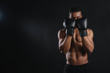 Genç gömleksiz Afrikalı-Amerikalı boksör boks eldiven siyah izole kamera bakıyor