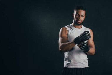 eldiven giymiş ve siyah izole kamera bakarak genç Afro-Amerikan kick boks