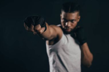 close-up view of young african american kickboxer training on black clipart