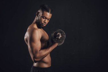 siyah izole dumbbell ile egzersiz kas gömleksiz Afrikalı-Amerikalı adam yan görünüm