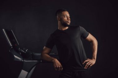 koşu bandı eğilerek ve Dış saha üzerinde izole siyah görünümlü atletik genç Afro-Amerikan adam