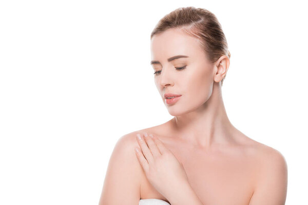 Женщина с чистой кожей касаясь собственного плеча изолированы на белом
