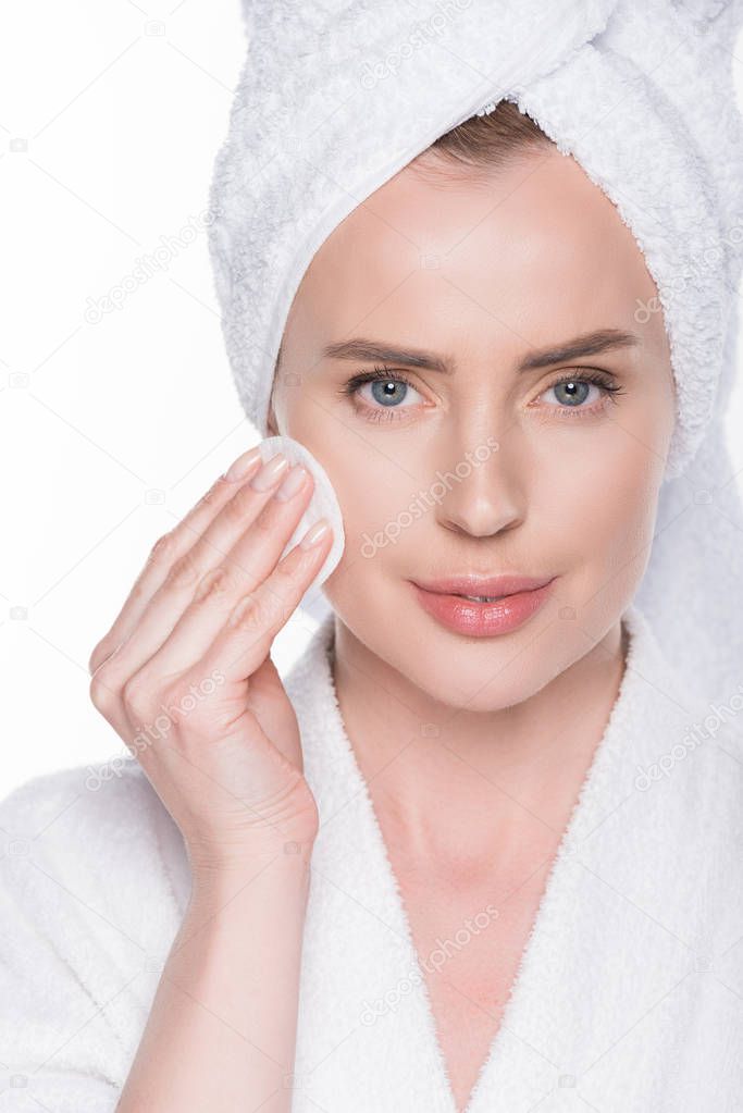 Female with clean skin using cotton pad isolated on white