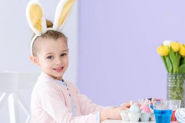 Tarafından tablo Easter Bunny kulaklar giyen oynayan kız çocuk yumurta renkli