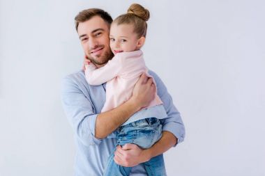 Baba küçük kızı mavi izole kucaklayan