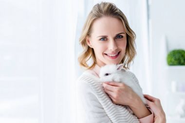 Sarışın kadın beyaz sarılma bunny pencere tarafından