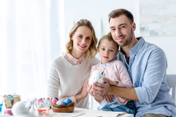 Familia Feliz Sosteniendo Conejo Pascua Con Huevos Pintados Mesa —  Fotos de Stock