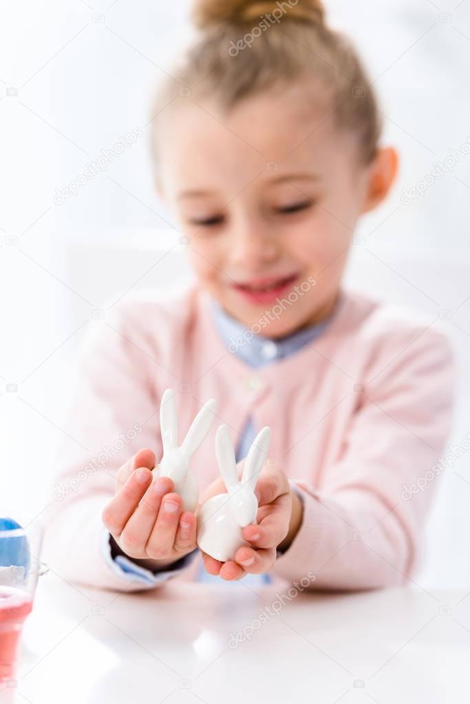 Easter bunny statuettes in hands of cute child