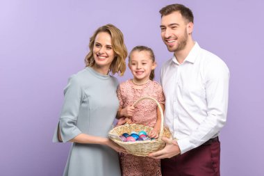 Violet izole Paskalya yumurtaları ile gülümseyen aile holding sepeti
