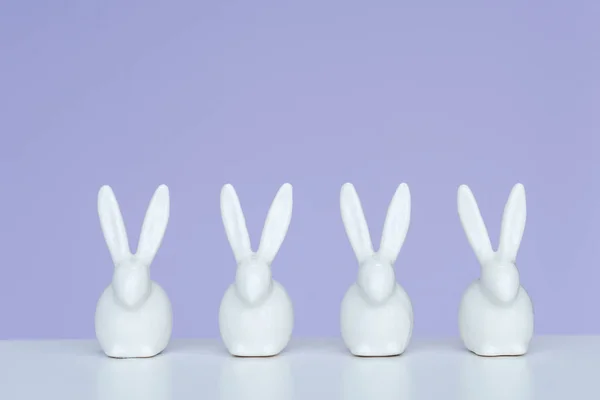 Rabbit Statuettes Row Violet Background — Stock Photo, Image