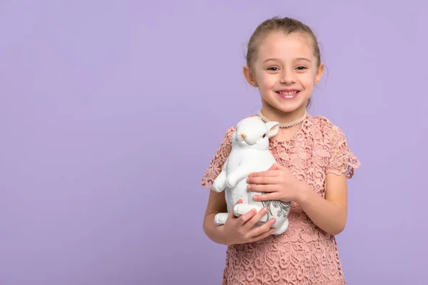 Gadis Kecil Dengan Patung Kelinci Untuk Paskah Terisolasi Pada Ungu — Stok Foto