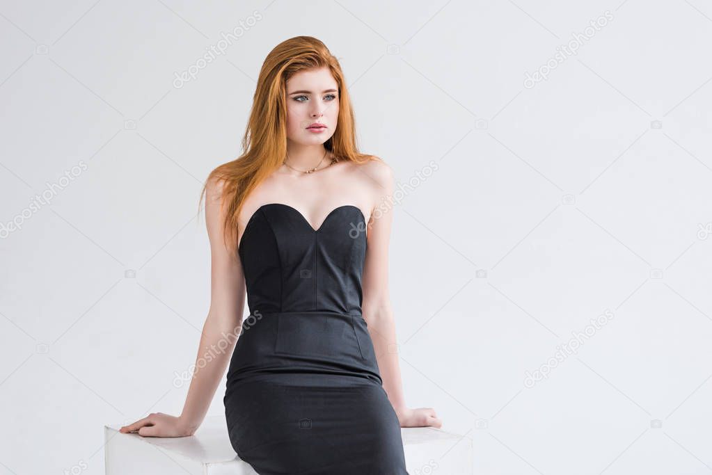 Young female fashion model with necklace in dress isolated on grey