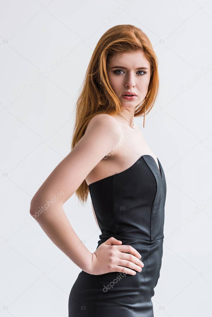 Stylish young female with earrings in black dress isolated on grey