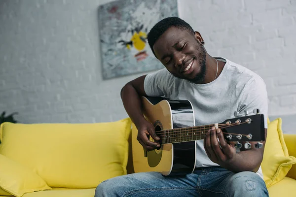 Guapo Sonriente Joven Afroamericano Hombre Tocando Guitarra Casa — Foto de Stock