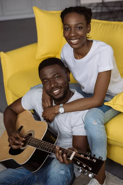 Glada Unga Afroamerikanska Par Med Akustisk Gitarr Ler Mot Kameran — Gratis stockfoto