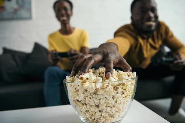 年轻的非洲裔美国夫妇的特写视图吃爆米花和玩游戏杆在家里 — 图库照片