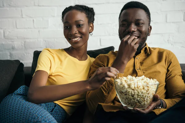 Smiling Young African American Couple Eating Popcorn While Sitting Sofa — Stock Photo, Image