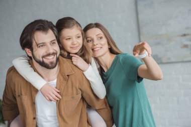 mutlu anne kızı ve kocası bir şeye işaret