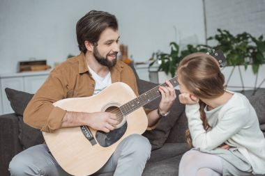 Baba gösteren kız barre akor oynamayı gülümseyen