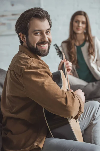 Mosolyogva Barátja Gitározni Látszó Fényképezőgép Otthon — Stock Fotó