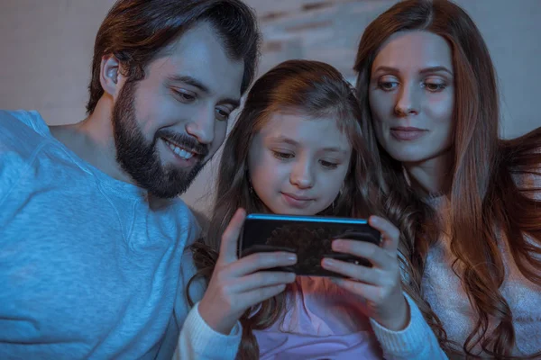 Pais Olhando Para Filha Usando Smartphone Noite — Fotografia de Stock