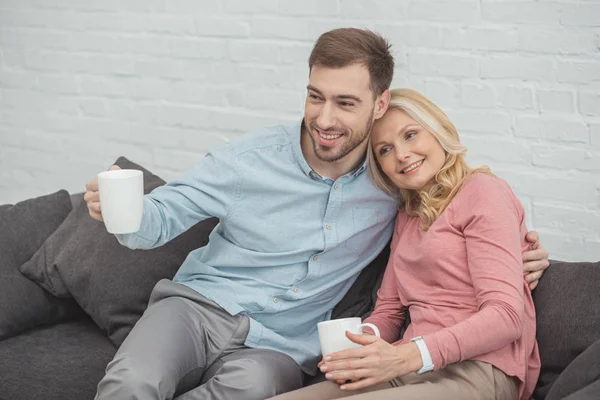 Portrait Smiling Mother Grown Son Cups Hot Drinks Home — Stock Photo, Image