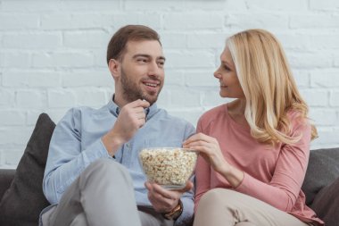 Anne ve oğlu birlikte evde film izlerken patlamış mısır yemek gülümseyen portresi