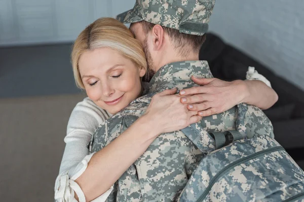 Lächelnde Mutter Umarmt Erwachsenen Sohn Militäruniform Hause — Stockfoto