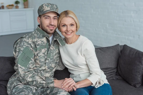 Portrait Smiling Mother Grown Son Military Uniform Holding Hands Sofa — Free Stock Photo