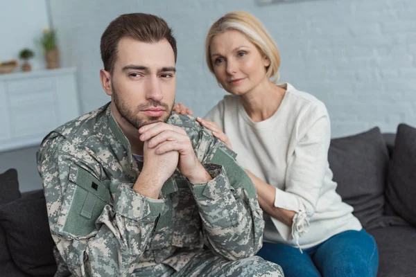 Portrait Thoughtful Man Military Uniform Mother Sofa Home — Stock Photo, Image